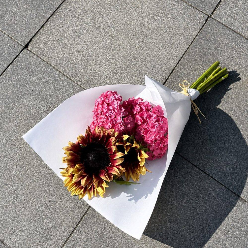 Bouquet rose et tournesols emballé, prêt à être livré à Paris